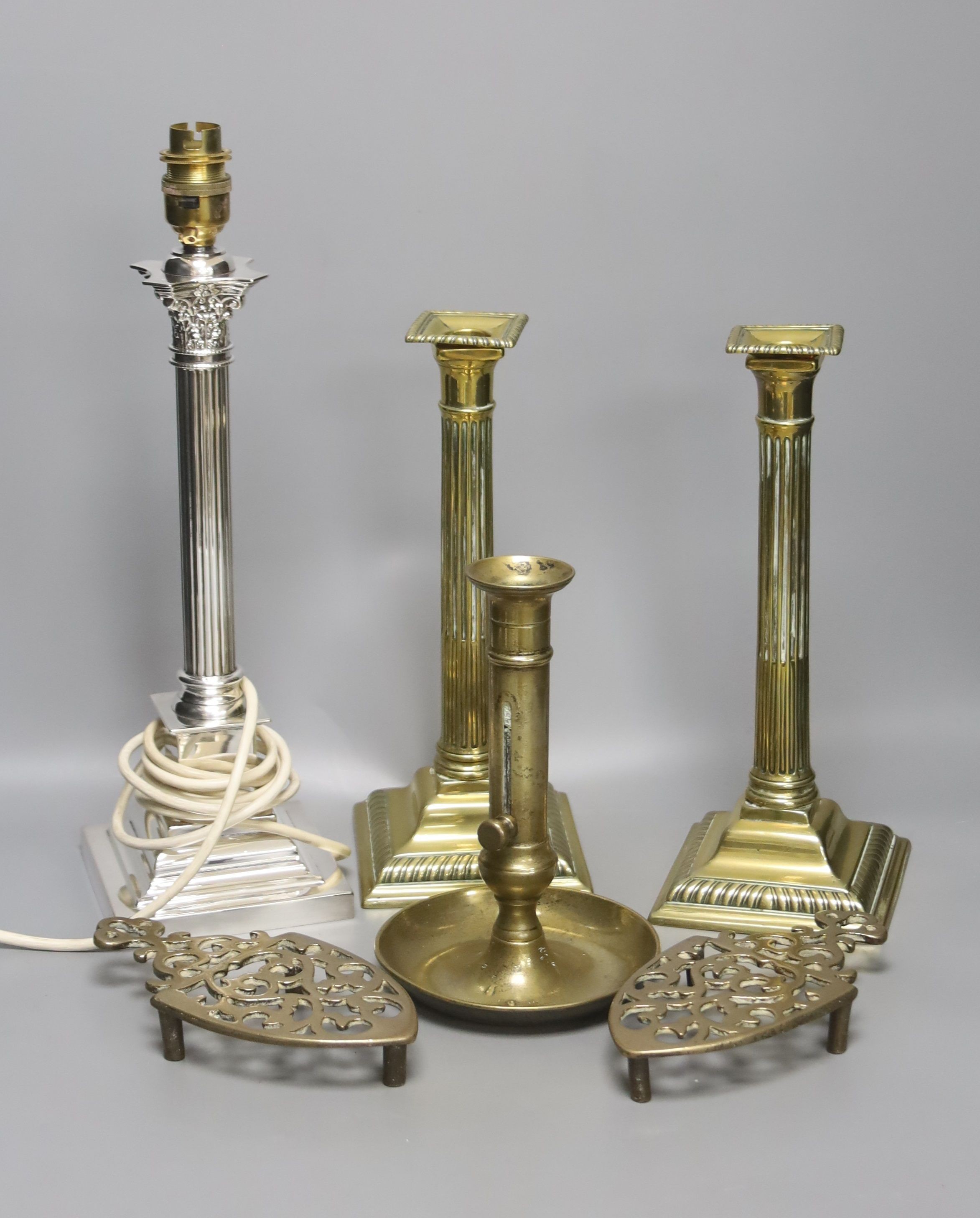 A pair of brass candlesticks, a telescopic candlestick and a silver plated table lamp base